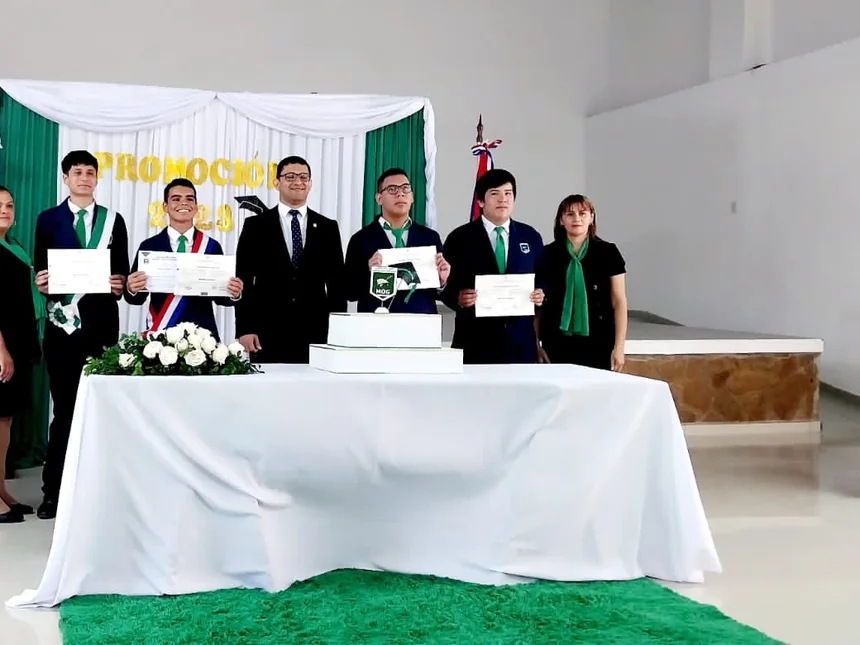 Egresados de la promoción 2025 con sus certificados junto a directivos y docentes en el acto de graduación